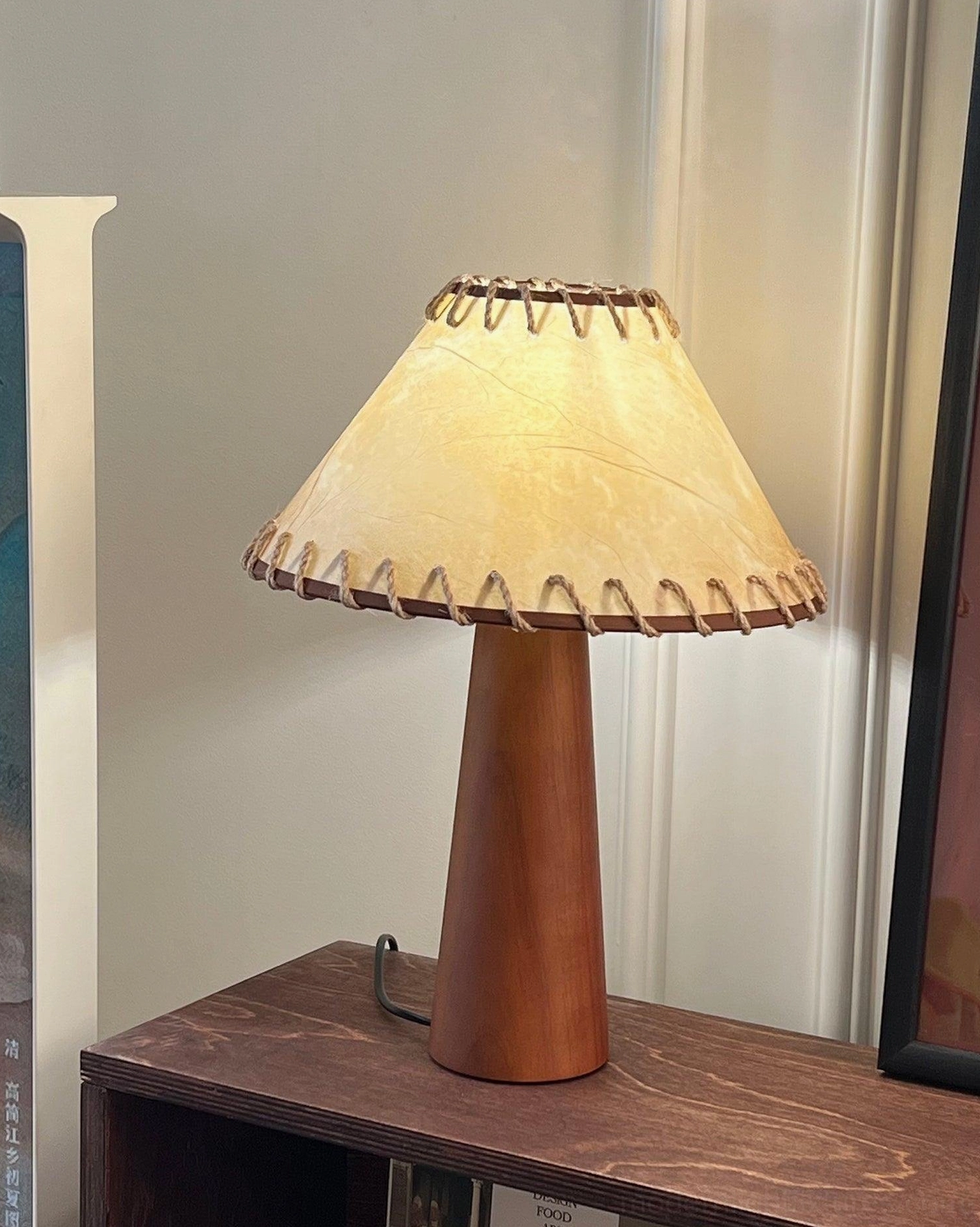 Handcrafted wooden table lamp displayed on dark wooden sideboard with vintage interior styling and warm home decor