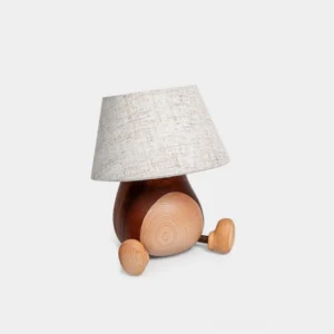 Whimsical wooden table lamp with toy car base and linen shade, front view on pure white background