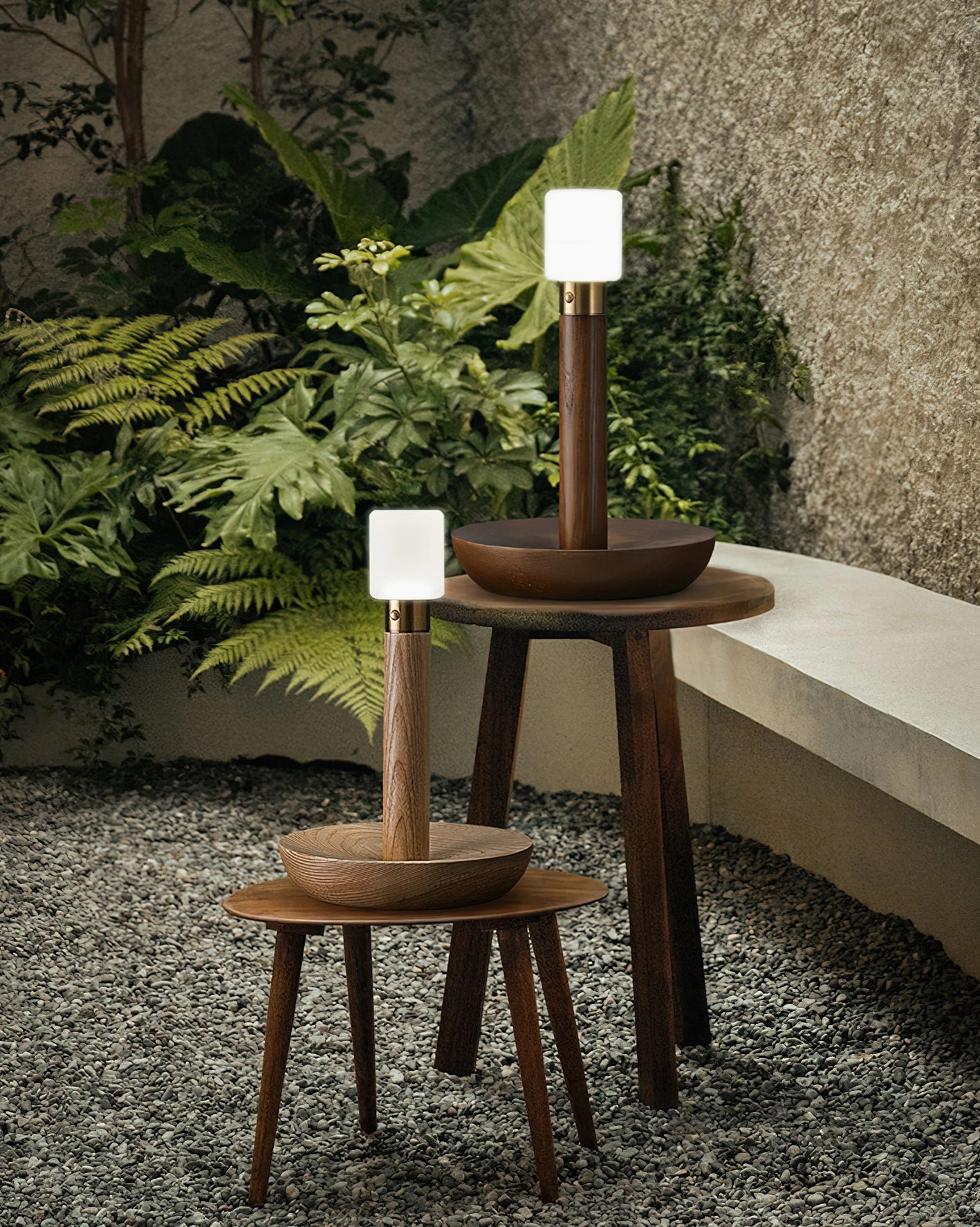 Two wooden table lamps in different sizes displayed in rustic outdoor courtyard wabi-sabi garden setting