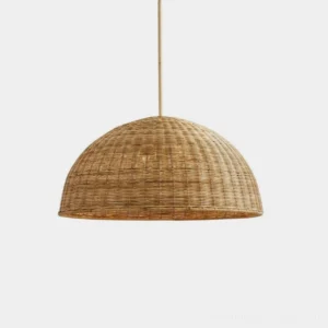 Woven rattan dome pendant light with natural tan half-dome shade and brass-tone hanging rod, studio front view