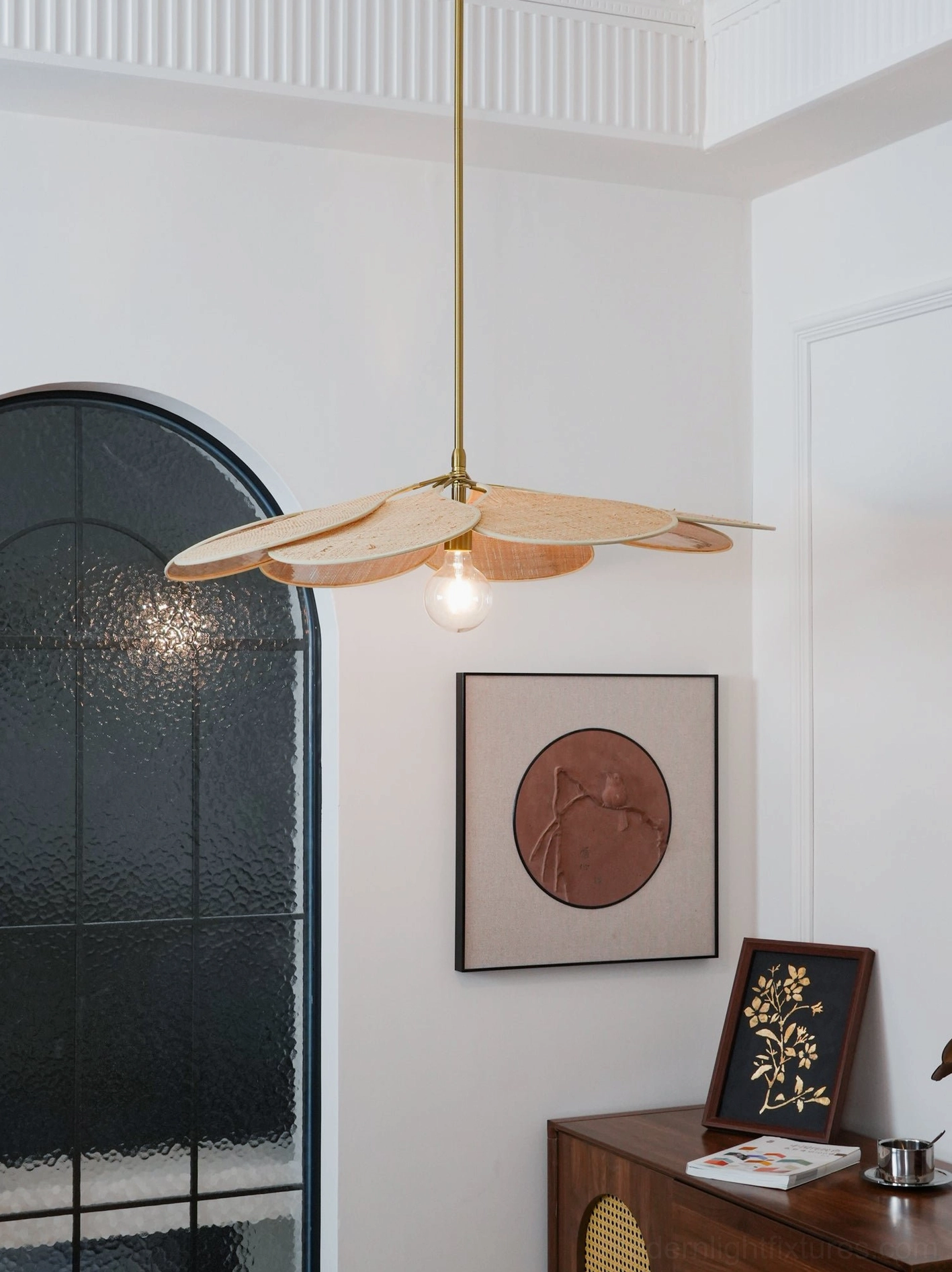Woven rattan pendant lamp with distinctive petal silhouette and warm golden metal accents