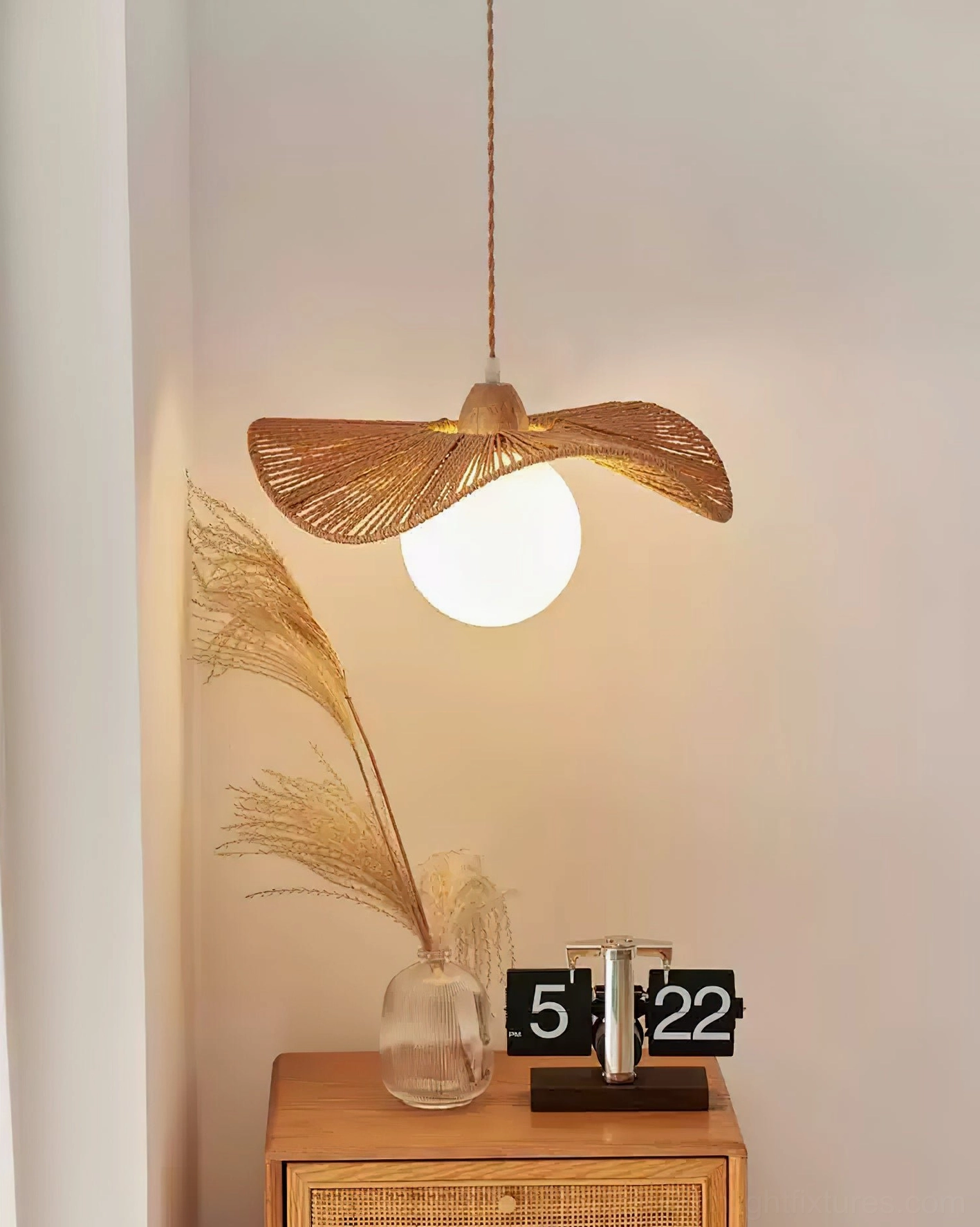 Artisanal woven rattan pendant light side view near wooden furniture and pampas grass decoration