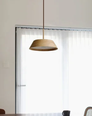 Wynora pendant light installed in modern dining area, warm 3000K light diffusing through wood shade over round table