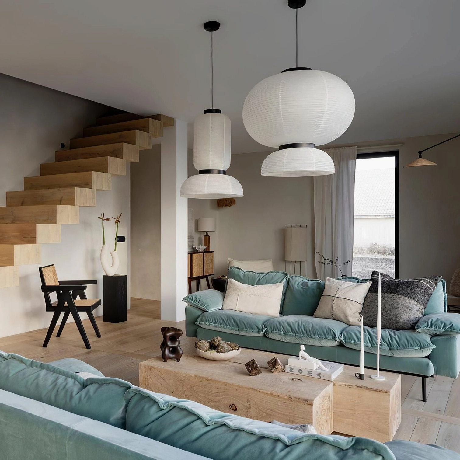 Collection of white paper pendant lamps in contemporary duplex living room with staircase, mixed sizes