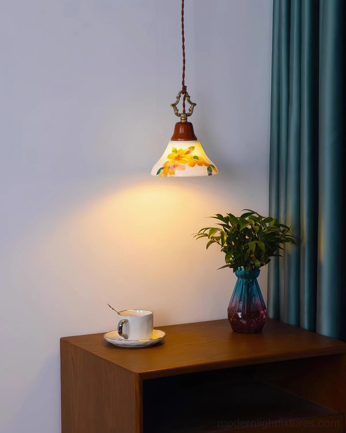 Yellow floral ceramic pendant light glowing above bedroom side table with teal curtain and coffee set, vintage farmhouse style