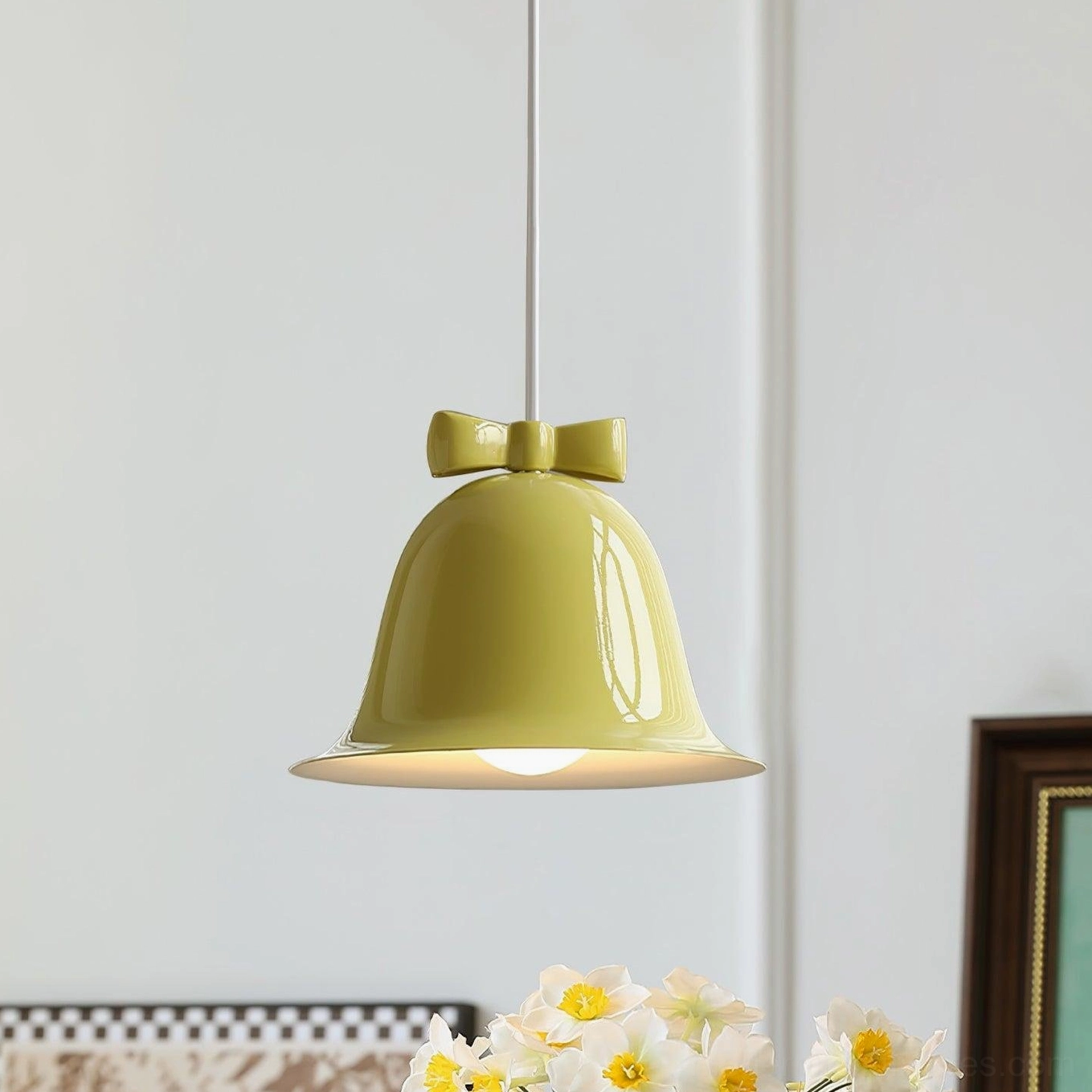 Yellow ceramic bell-shaped pendant light with brown bow in bright studio background