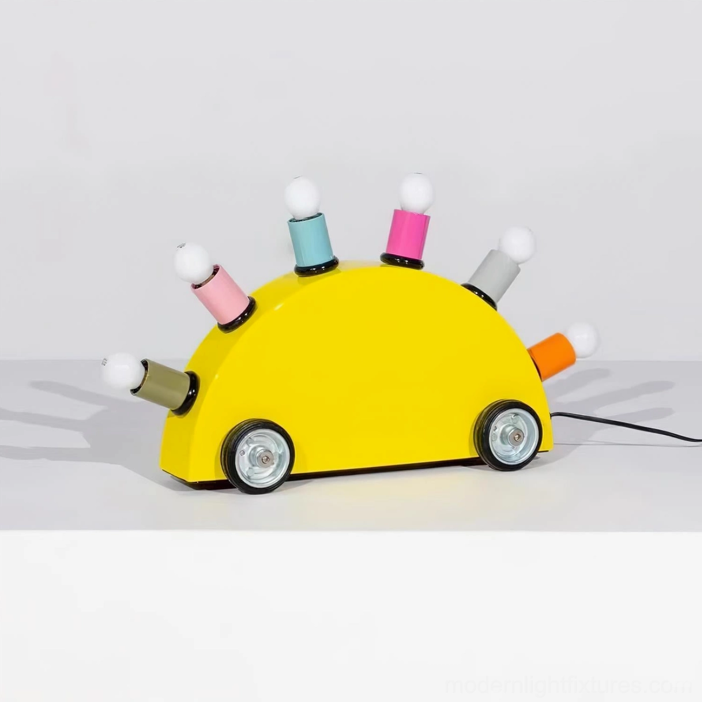 Yellow cartoon car table lamp side view with assorted colored bulb bases and power cord