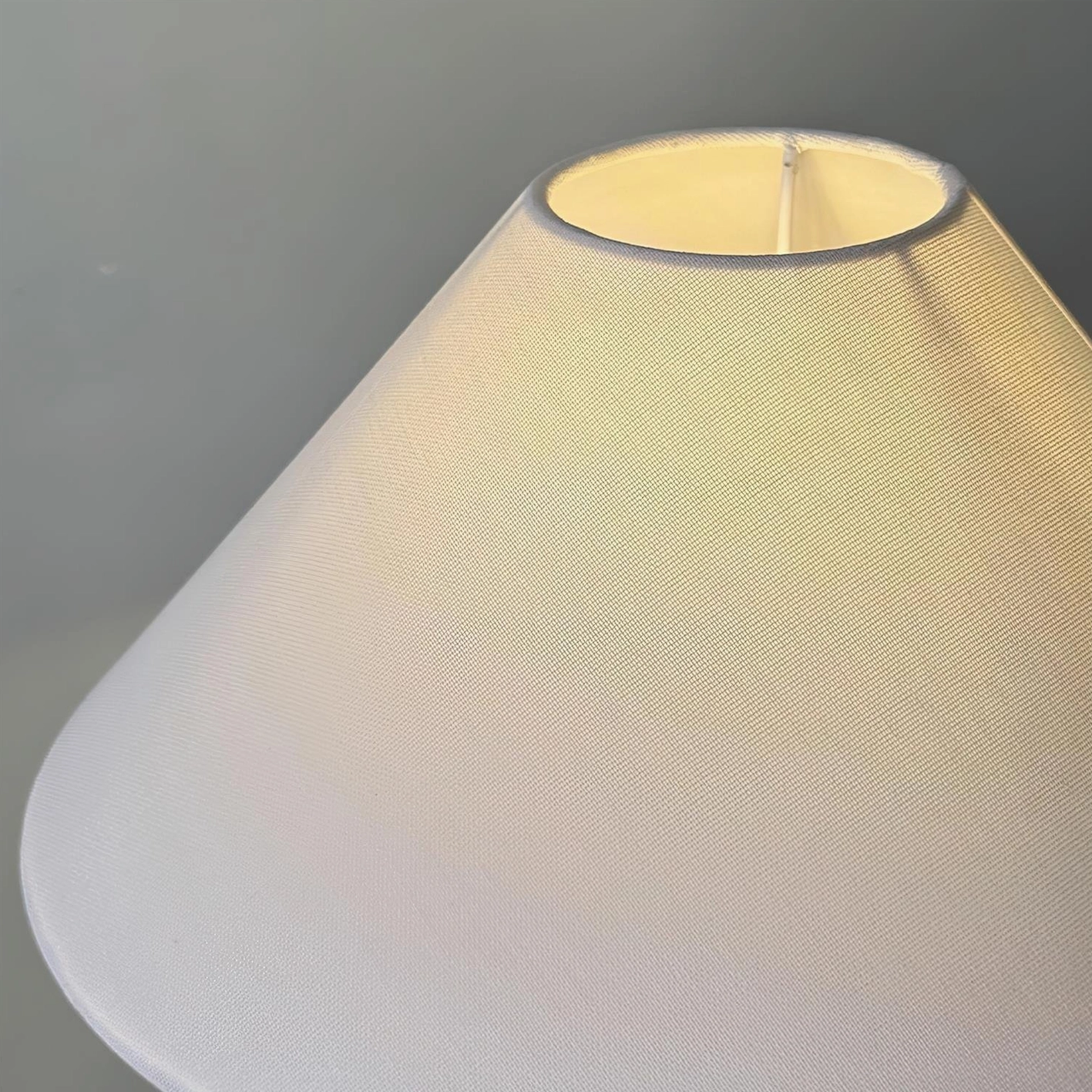 Yellow ceramic floral table lamp with blue botanical design, fabric shade creating warm ambient light diffusion