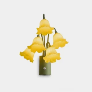 Yellow lily bloom wall sconce with ruffled acrylic flower shades and sage green iron body on white background