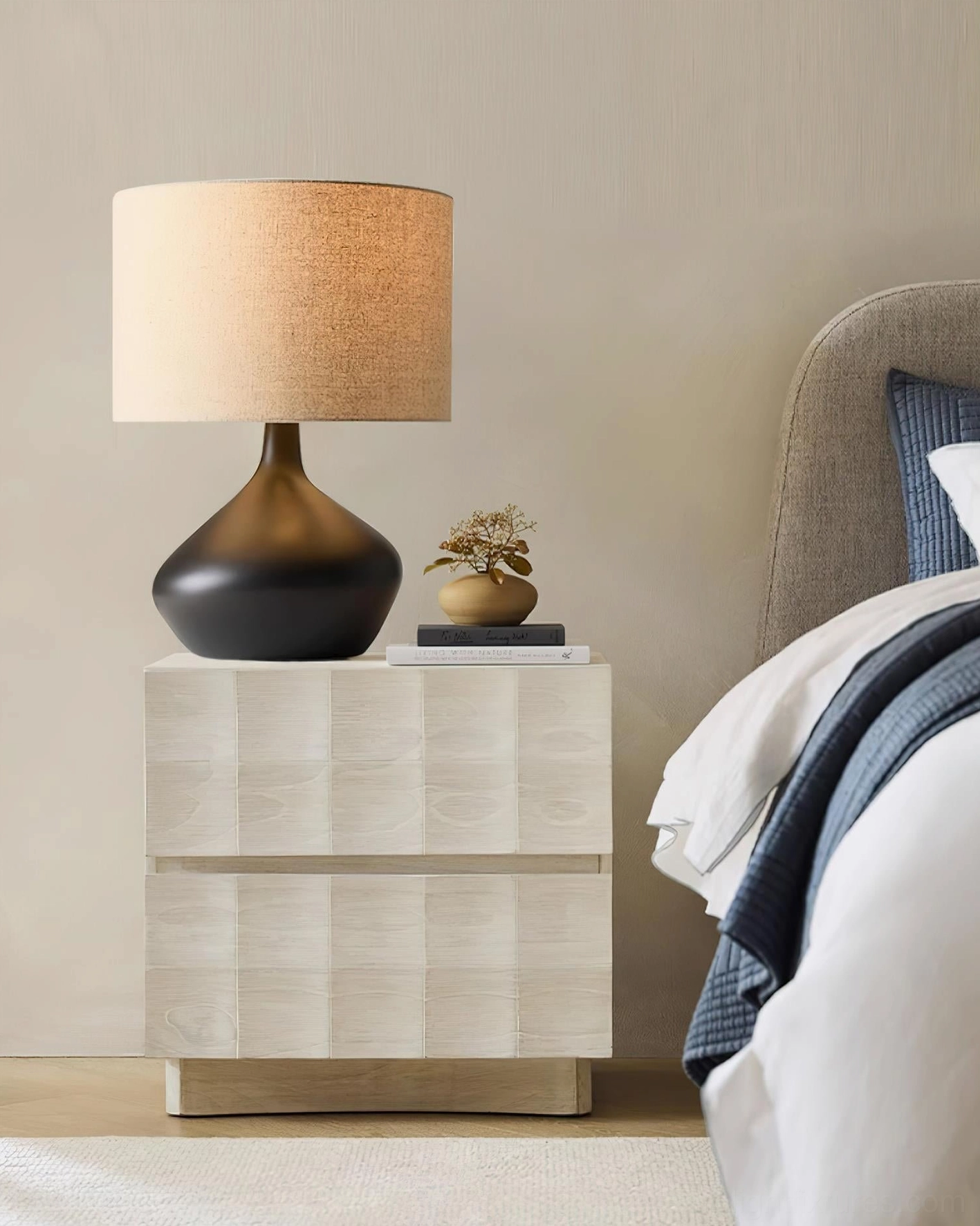 Zen ceramic table lamp with black curved base and tan drum shade on bedroom nightstand, interior styling