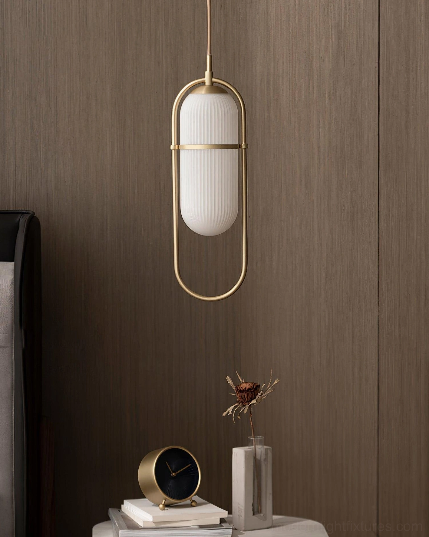 Brass gold Zesta pendant light mounted as bedside accent above bedroom wall sconce area