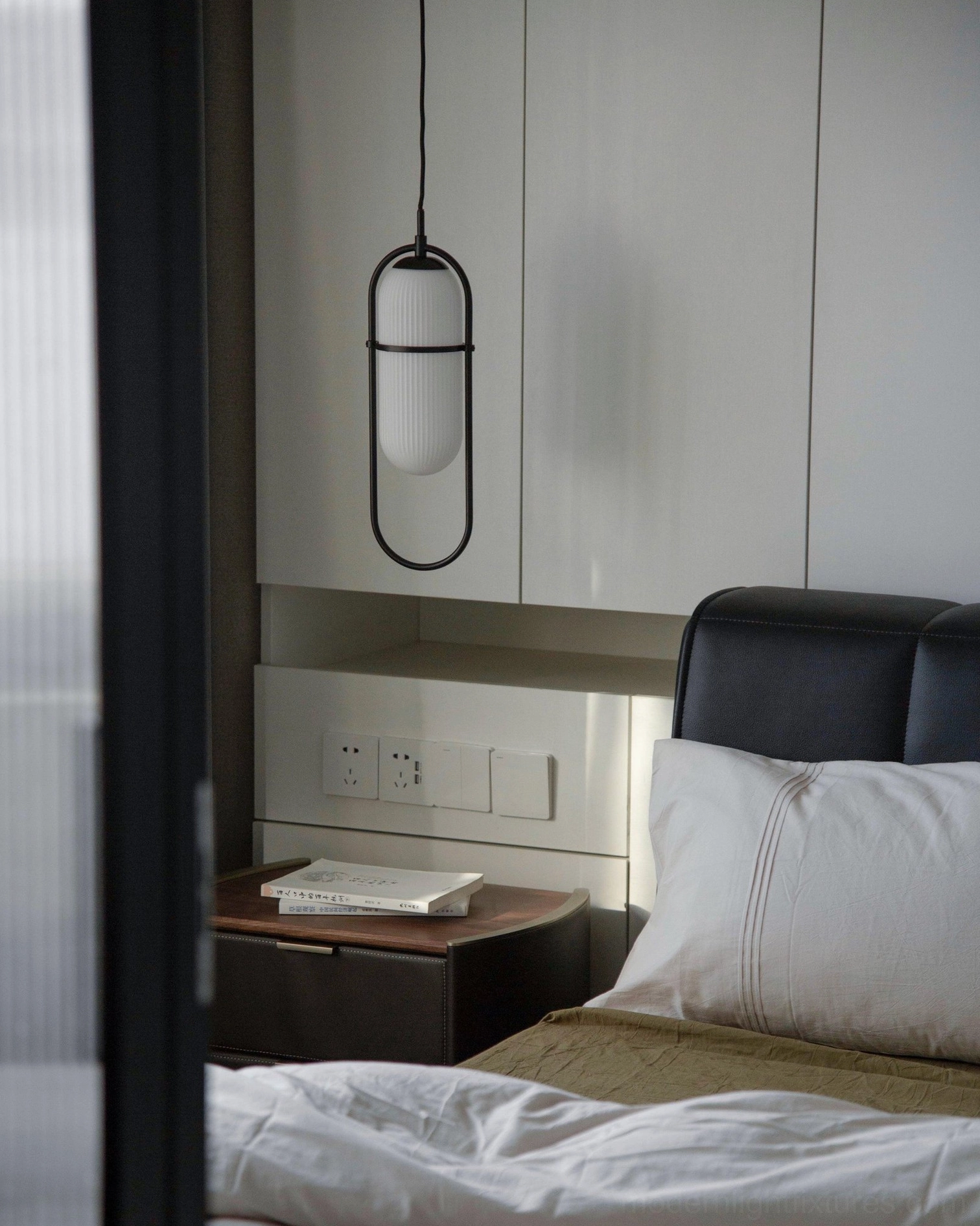Modern master bedroom interior featuring brass gold Zesta pendant light as sculptural wall accent