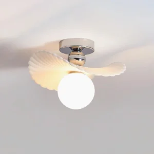 Zinola ceiling light with frosted glass diffuser and warm ambient glow, three-quarter perspective showing ribbed shell design